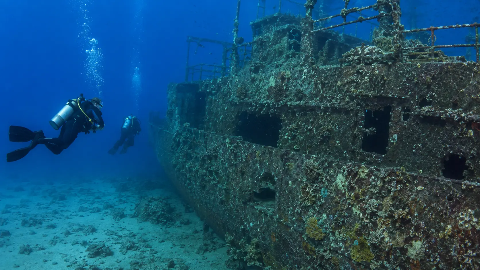 Scuba divers viewing the exterior of an underwater wreck near Hurghada